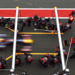A CHRO represented as an F1 pit crew chief, standing next to a Formula 1 car constructed of business symbols