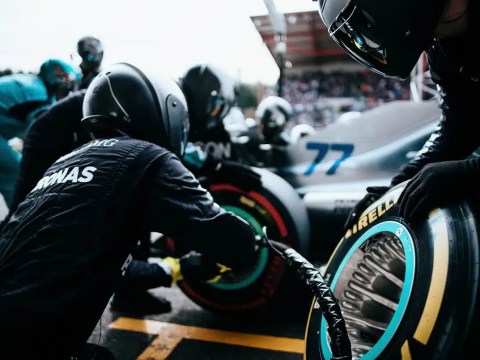 Managing Crises in Startups: Red Flags and Safety Cars. Formula 1 pit crew working on a car during a race, symbolizing crisis management in action.