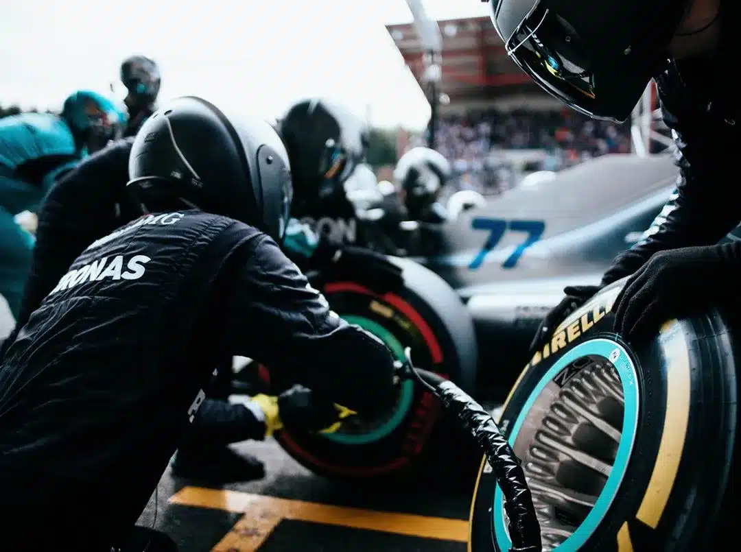 Managing Crises in Startups: Red Flags and Safety Cars. Formula 1 pit crew working on a car during a race, symbolizing crisis management in action. 