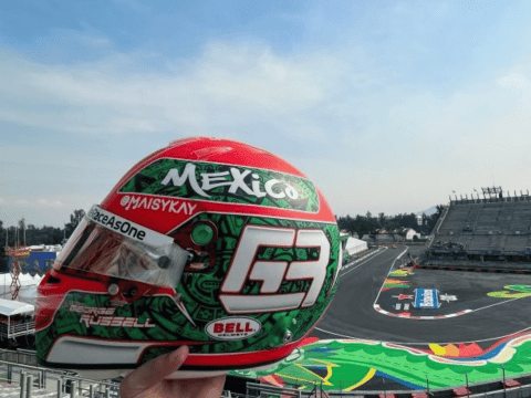 An F1 helmet, with colors reflecting the Mexican flag, racing past a modern office building representing nearshoring.