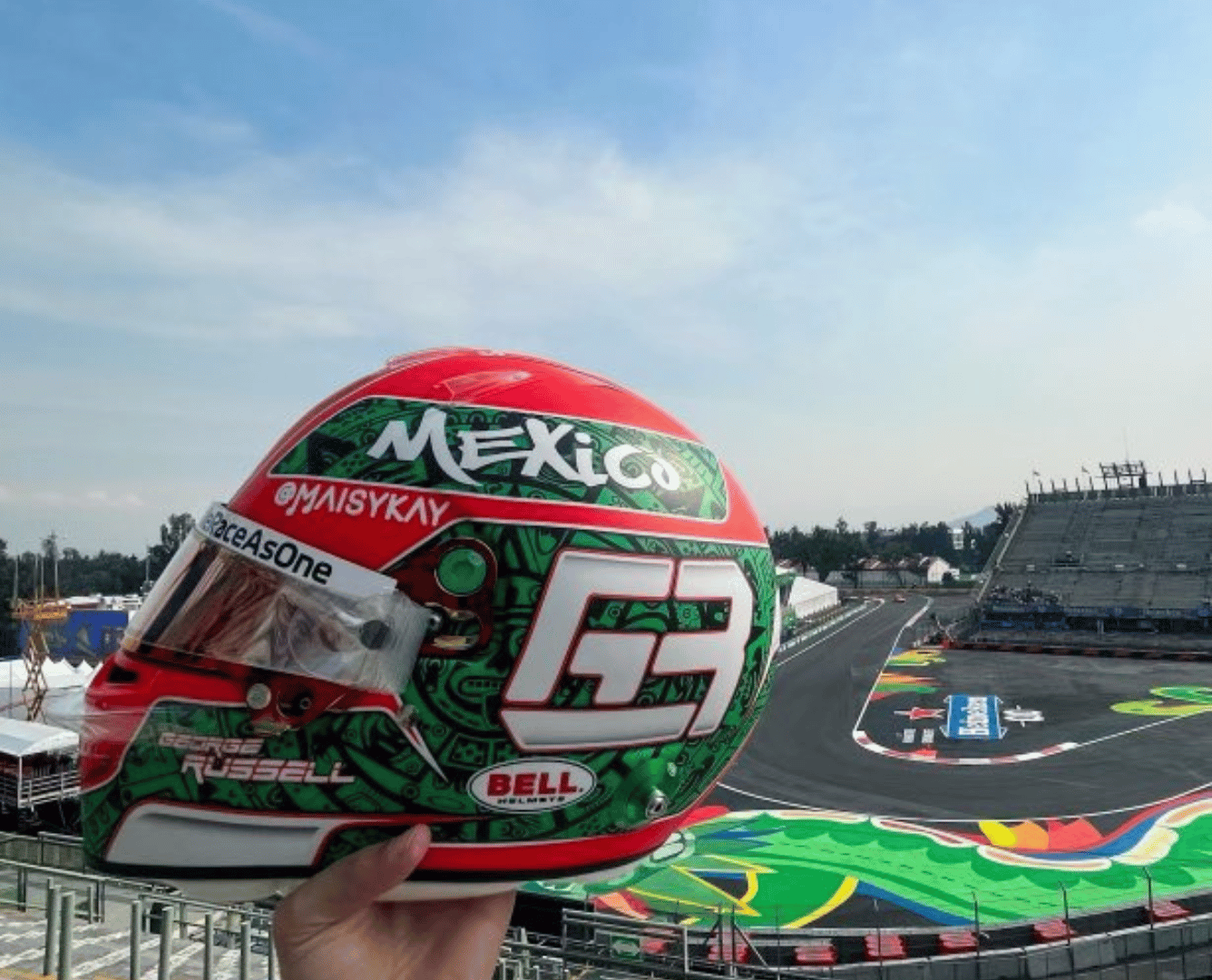 An F1 helmet, with colors reflecting the Mexican flag, racing past a modern office building representing nearshoring.