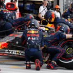 A Formula 1 pit crew swiftly servicing a race car during a pit stop, symbolizing the 'Pit Crew Principle' in executive search