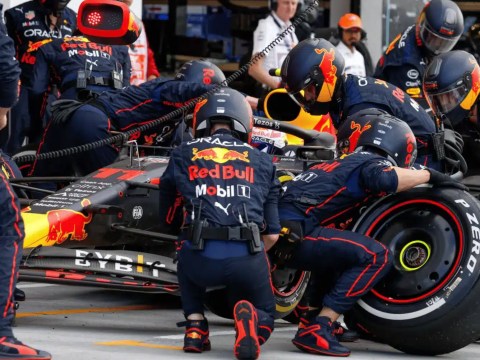A Formula 1 pit crew swiftly servicing a race car during a pit stop, symbolizing the 'Pit Crew Principle' in executive search