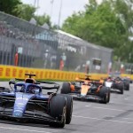Formula 1 car alongside business executives symbolizing the link between F1 strategies and future HR leadership.