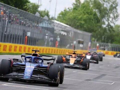 Formula 1 car alongside business executives symbolizing the link between F1 strategies and future HR leadership.
