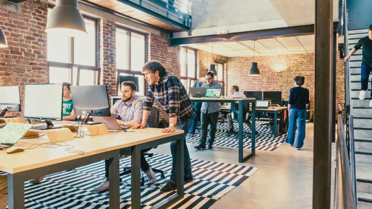 Diverse professionals brainstorming talent acquisition strategies for 2023 in a modern office.