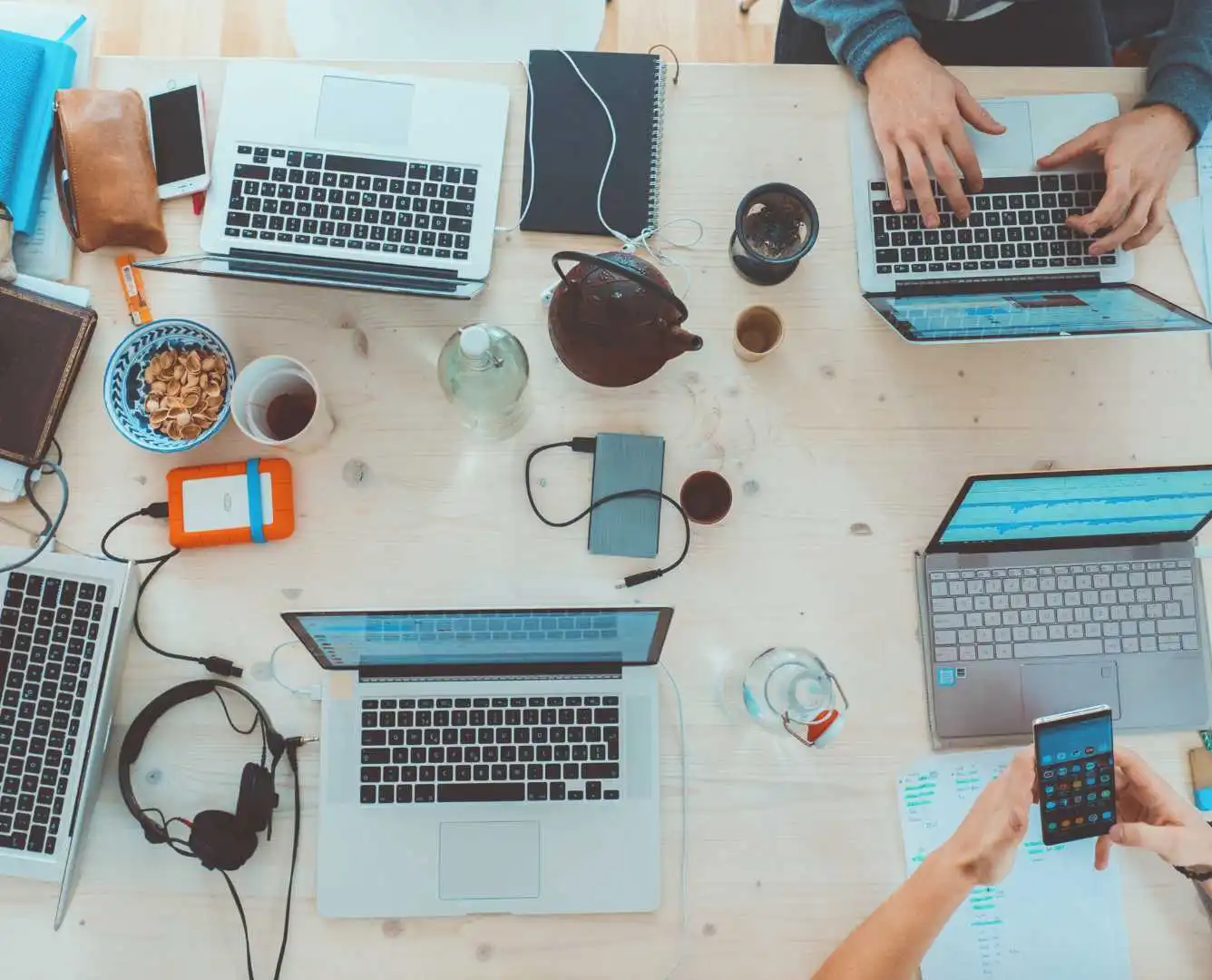 Executive recruitment in tech- Group of diverse executive professionals discussing strategies, surrounded by tech devices in a modern office setting