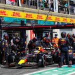 F1 pit team and global professionals collaborate, symbolizing Brainshoring's blend of speed and intellect.