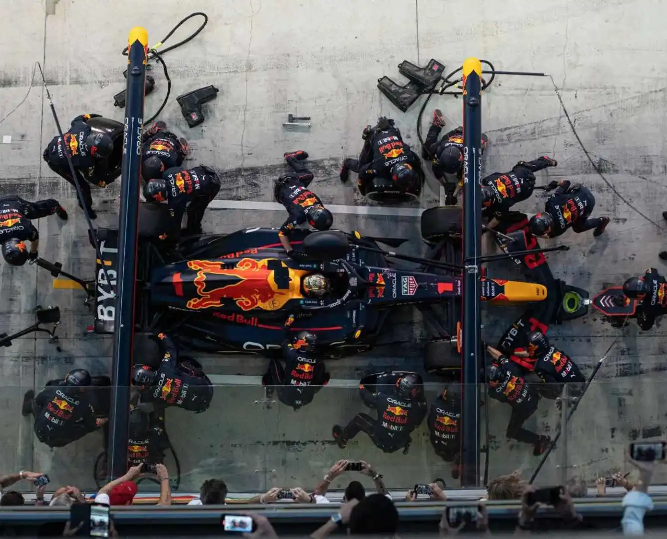 Formula 1 pit stop efficiency combined with COO strategy planning in a boardroom.