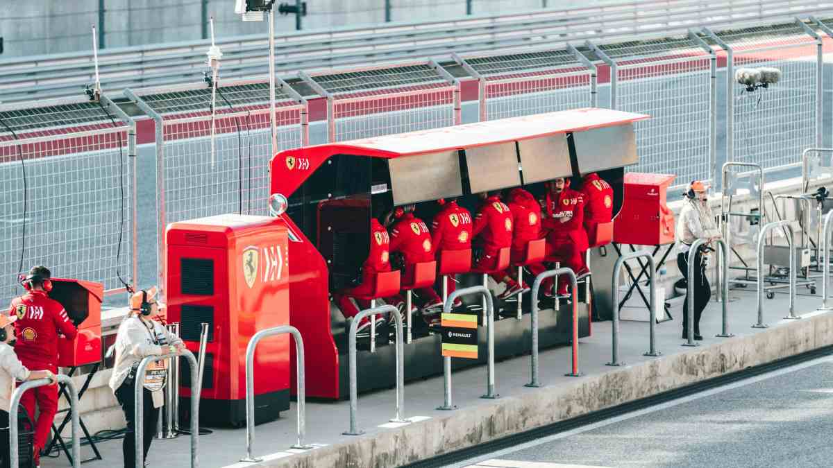 F1 team principal collaborating with pit wall crew contrasted with founder facing empty COO chair representing leadership diagnostic