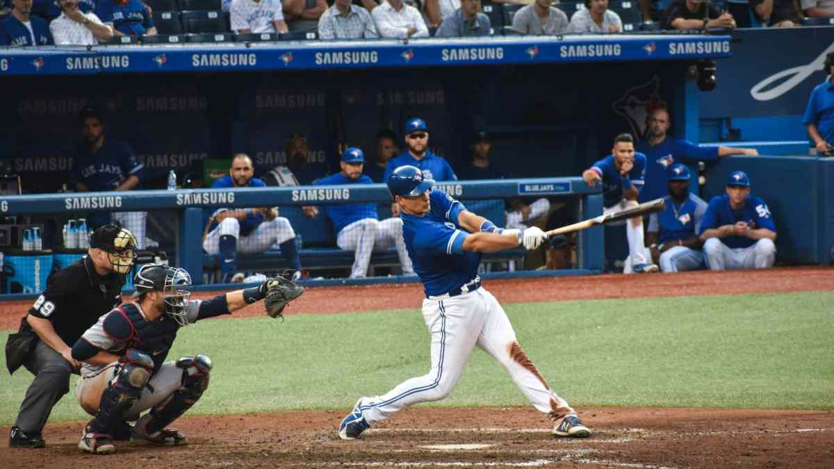 Baseball player reaching first base safely - representing on-base percentage executive hiring strategy