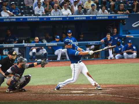 Baseball player reaching first base safely - representing on-base percentage executive hiring strategy