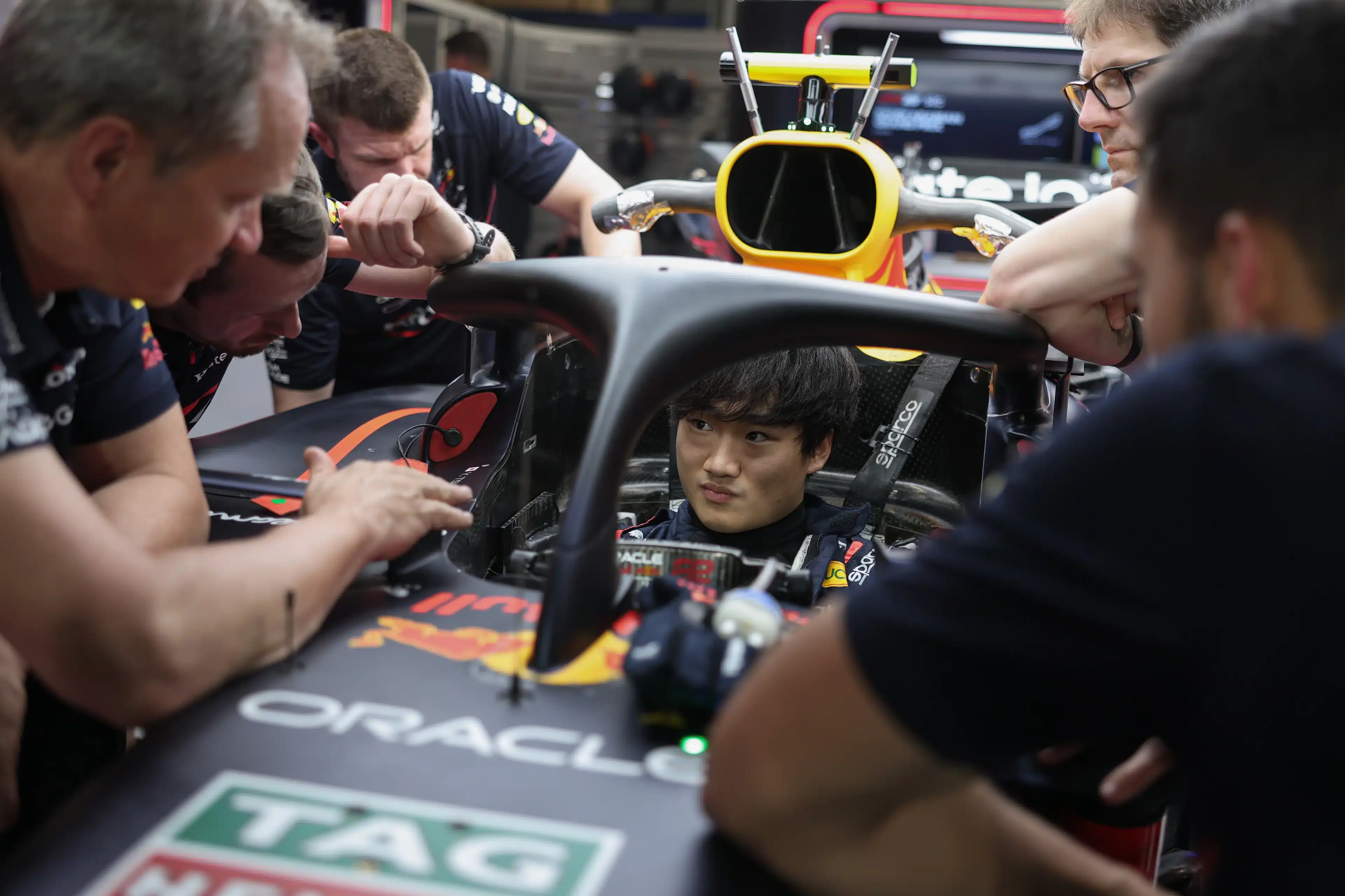 Race driver stationary in pit lane while competitors pass on track, representing the cost of accepting a counter-offer while career momentum moves on