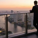 Founder contemplating next chapter while overlooking city skyline at dawn