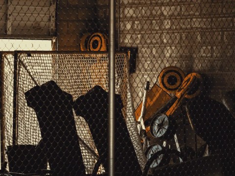 Sports Executive Search Conflicts: Locked storage cage in a stadium tunnel, evoking restricted access in sports executive search