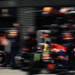 Formula 1 garage with a car mid-rebuild on stands, symbolizing executive hiring readiness before results