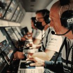 Race engineer's headset resting on a pit-wall console, representing board communication discipline