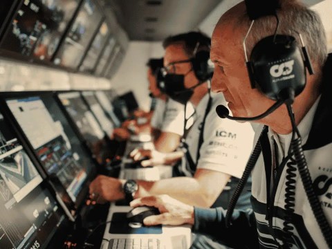 Race engineer's headset resting on a pit-wall console, representing board communication discipline